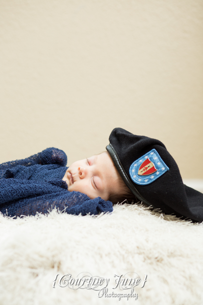 newborn photographer photographing a newborn portrait with daddy's army cap on 