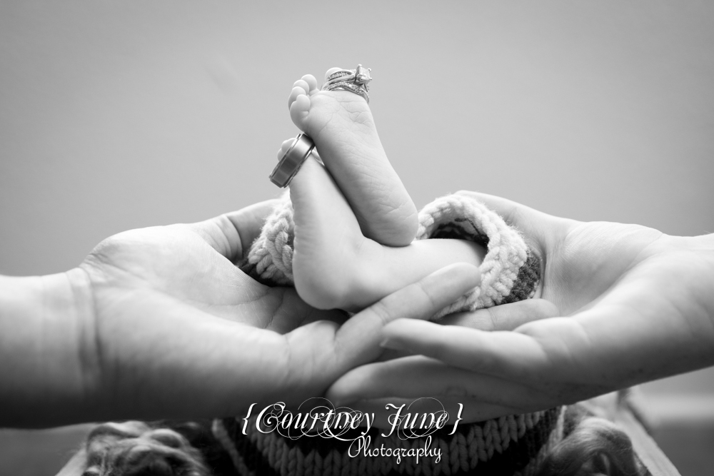 newborn photographer photographing an ewborn baby's feet with mom and dad's wedding rings 