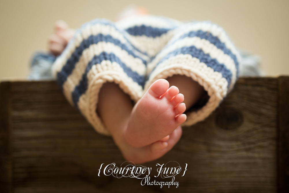 newborn photographer photographing a newborn baby's bare feet 